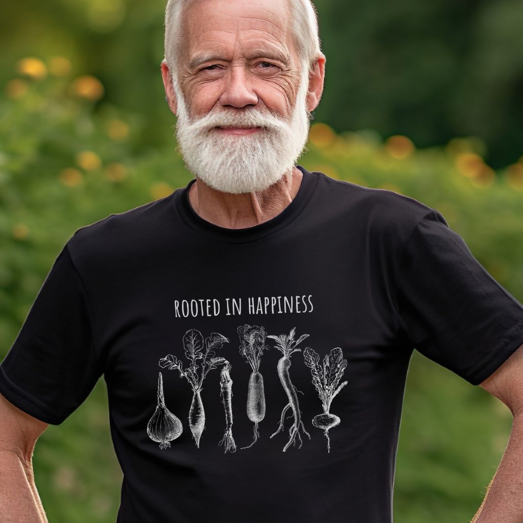 Man wearing a black gardening t-shirt that has root vegetables and says Rooted in Happiness