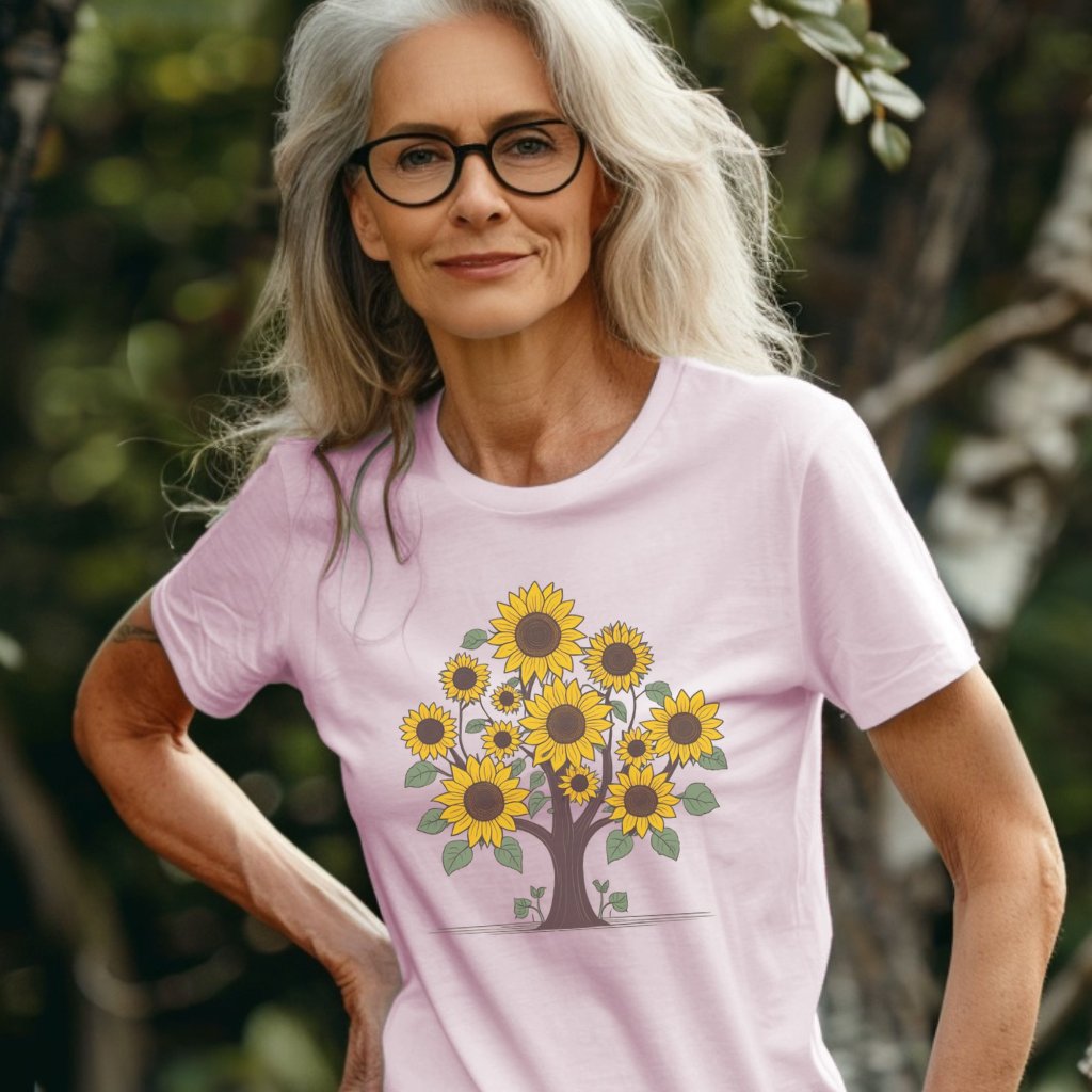 Woman outdoors wearing a pink flower t-shirt with a tree made out of sunflowers