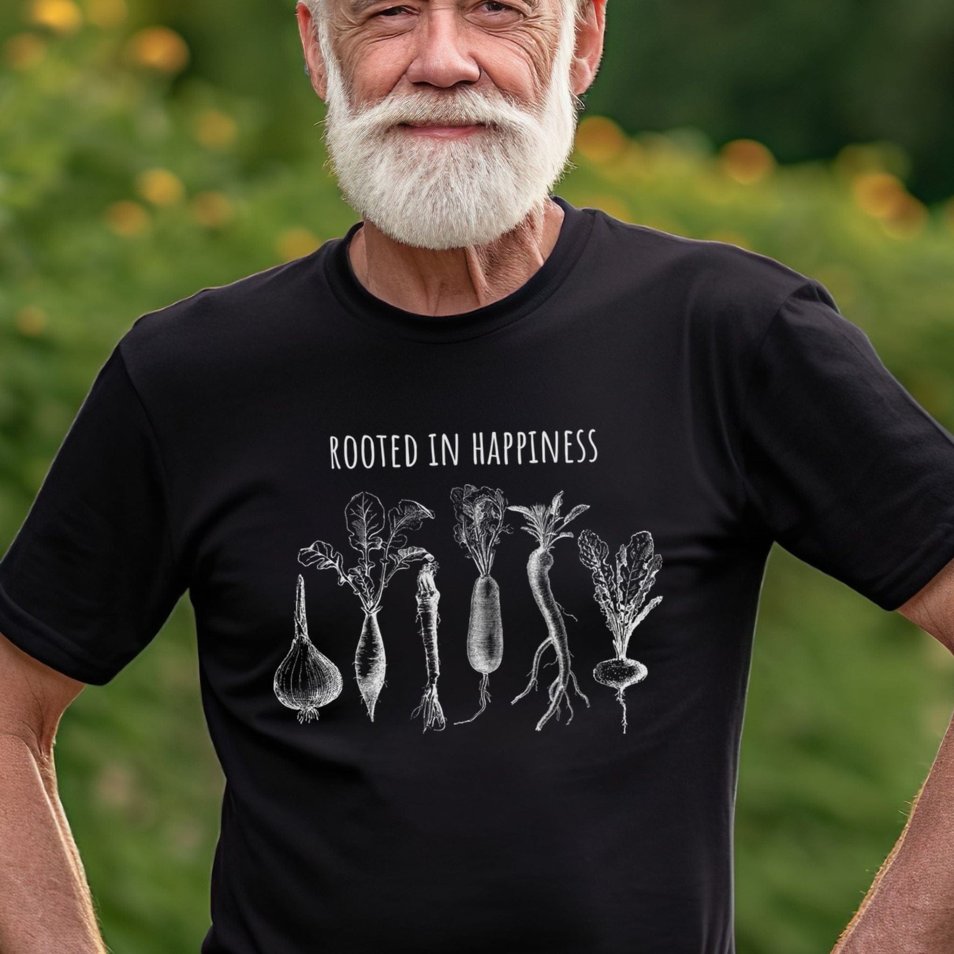 Man wearing a black gardening tee shirt with vegetables on it and says Rooted in Happiness